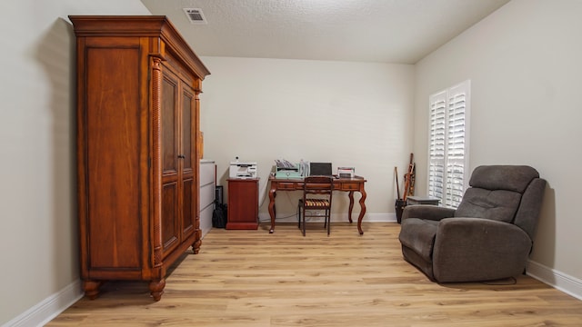 sitting room with a textured ceiling and light wood-type flooring