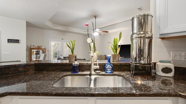 446 Mango Ln, Freeport, FL 32439 - kitchen with dark stone countertops, white cabinetry, ceiling fan, and french doors