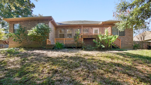 back of house featuring a lawn and a wooden deck