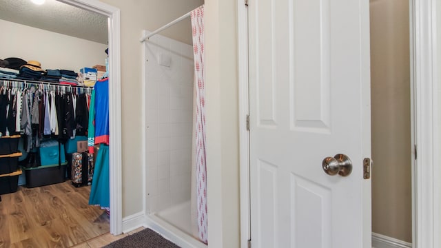 bathroom featuring a shower with shower curtain, a textured ceiling, and hardwood / wood-style flooring