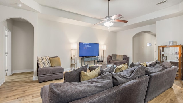 446 Mango Ln, Freeport, FL 32439 - living room featuring arched walkways, light wood-style floors, ceiling fan, and a raised ceiling