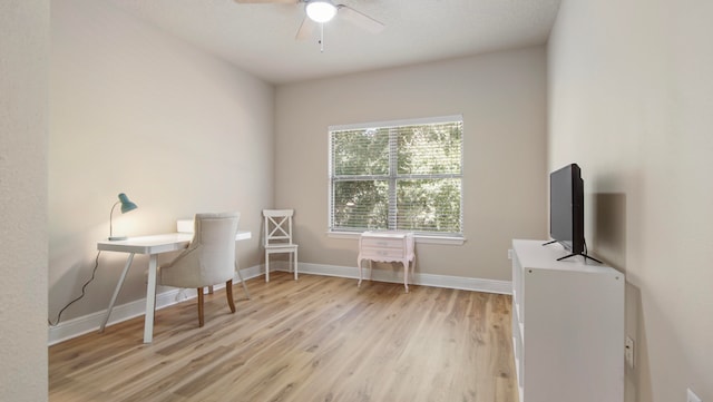 office with light wood-type flooring and ceiling fan