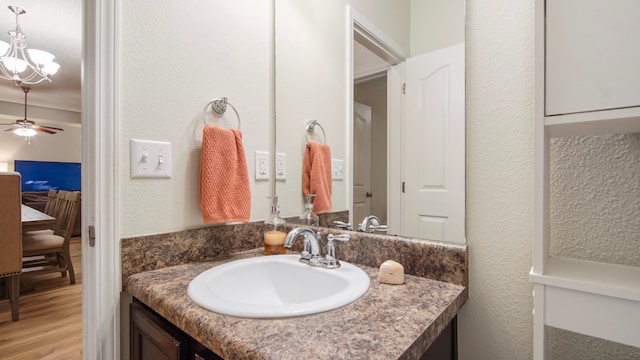 bathroom featuring vanity, wood-type flooring, and ceiling fan with notable chandelier