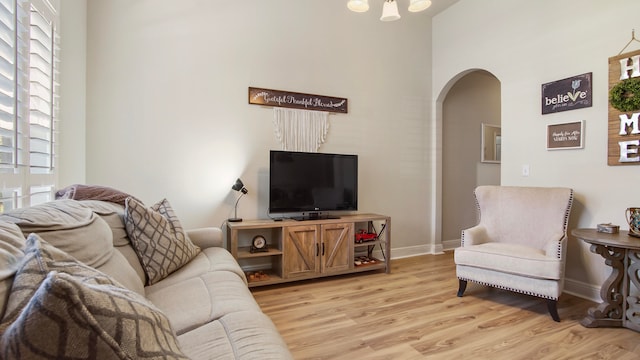 living room with light hardwood / wood-style floors and a high ceiling