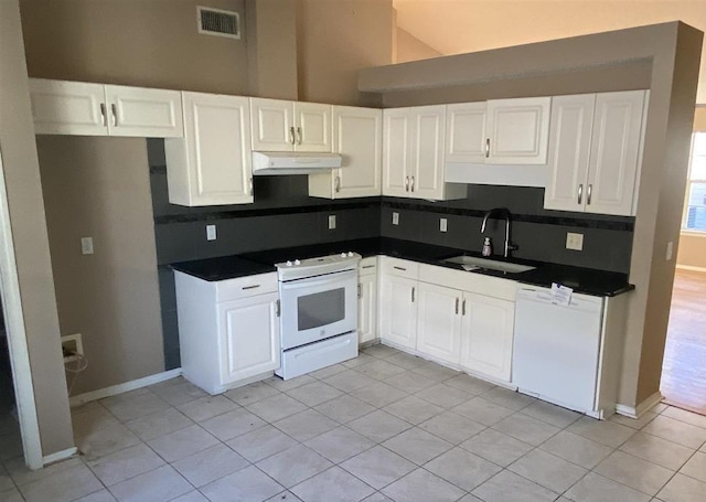 kitchen featuring sink, tasteful backsplash, light tile patterned floors, white appliances, and white cabinets