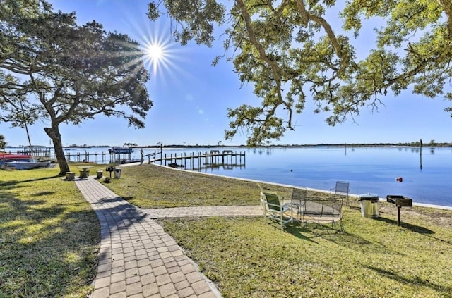 dock area with a lawn and a water view