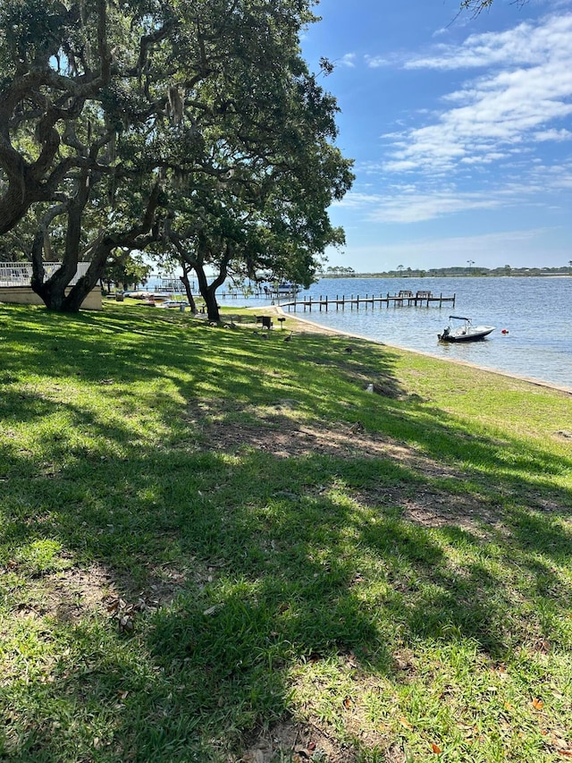 view of dock featuring a water view and a lawn