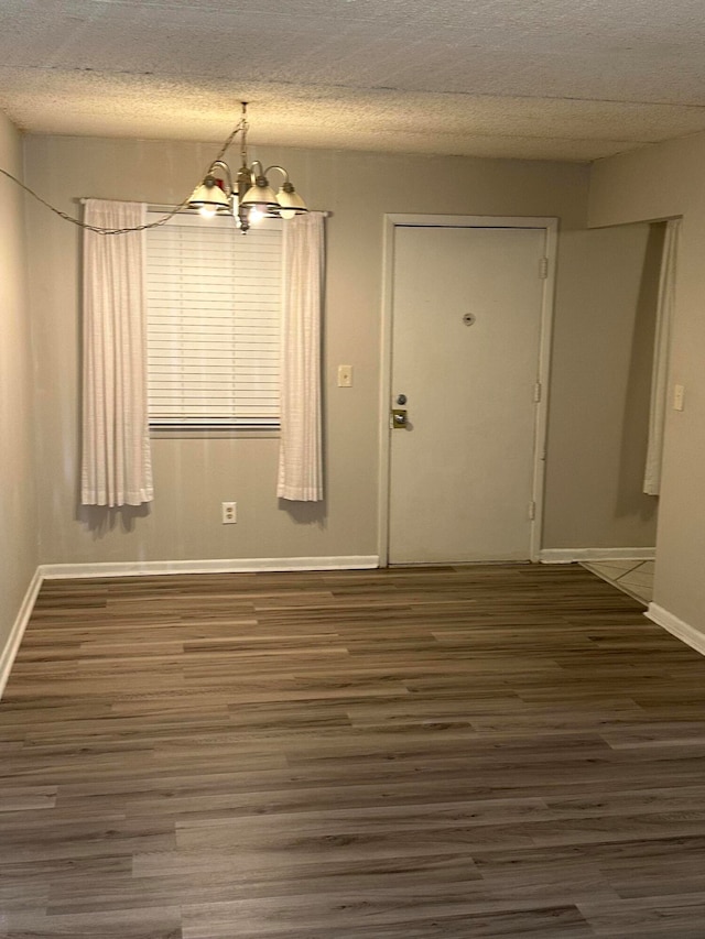 unfurnished dining area featuring dark hardwood / wood-style floors and a notable chandelier