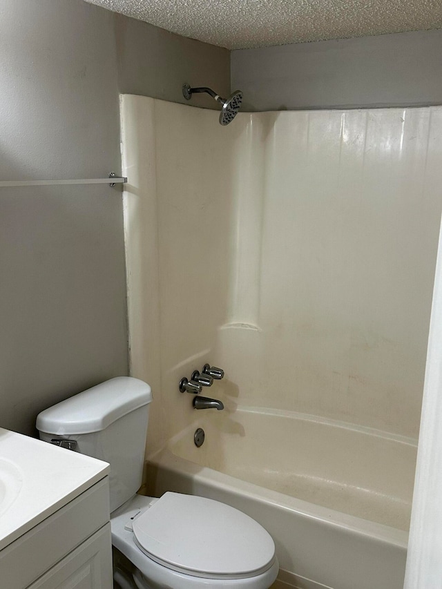 full bathroom featuring vanity, a textured ceiling, toilet, and tub / shower combination