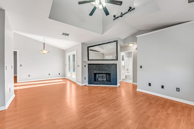 unfurnished living room featuring a fireplace, light hardwood / wood-style flooring, ceiling fan, and lofted ceiling