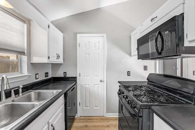 kitchen featuring lofted ceiling, black appliances, sink, light wood-type flooring, and white cabinetry