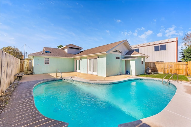 view of swimming pool featuring a patio area and french doors