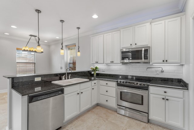 kitchen with decorative backsplash, stainless steel appliances, sink, pendant lighting, and white cabinetry