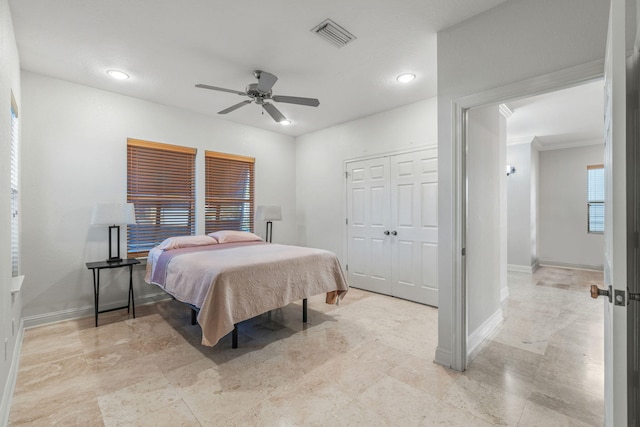 bedroom featuring ceiling fan, a closet, and crown molding