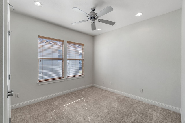 empty room featuring ceiling fan and light colored carpet