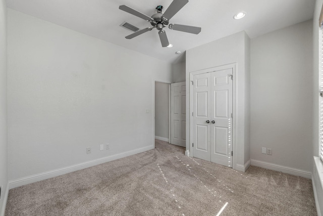 unfurnished bedroom with carpet, a closet, and ceiling fan