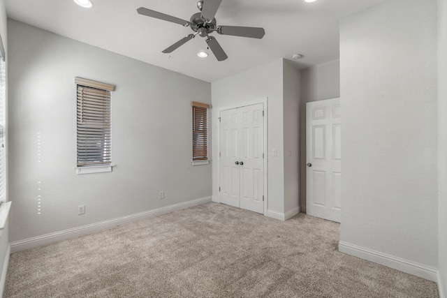 unfurnished bedroom featuring ceiling fan, light colored carpet, and a closet