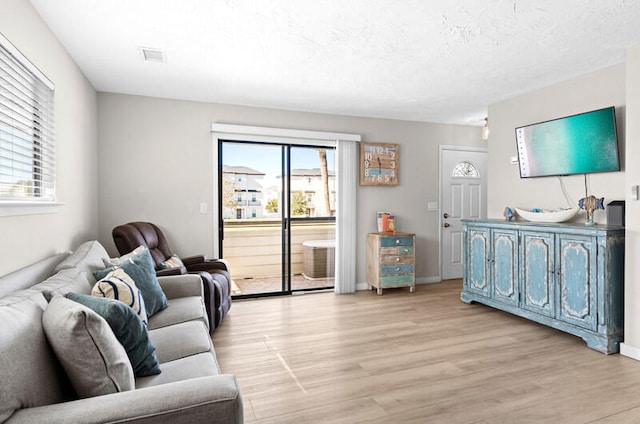 living room featuring light hardwood / wood-style flooring and a textured ceiling