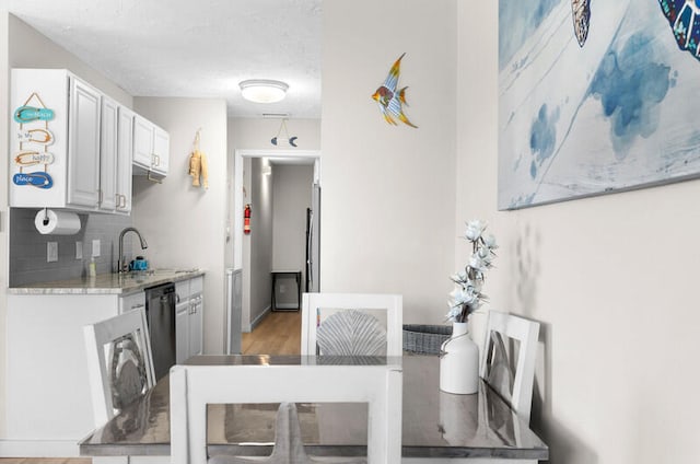 dining area with wood-type flooring, a textured ceiling, and sink