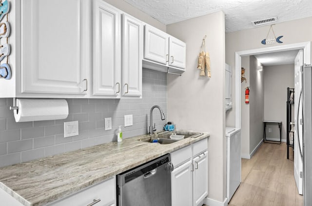 kitchen with sink, light stone counters, light hardwood / wood-style flooring, stainless steel dishwasher, and white cabinets