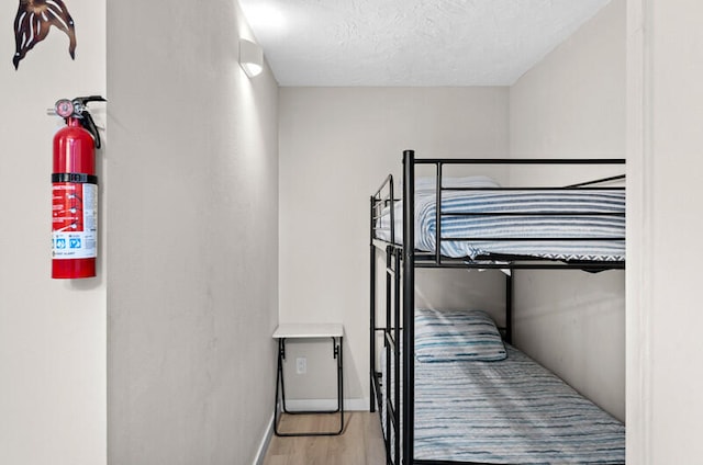 bedroom featuring a textured ceiling and light wood-type flooring