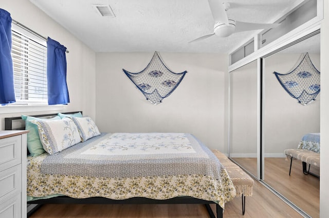 bedroom featuring ceiling fan, light hardwood / wood-style flooring, and a closet