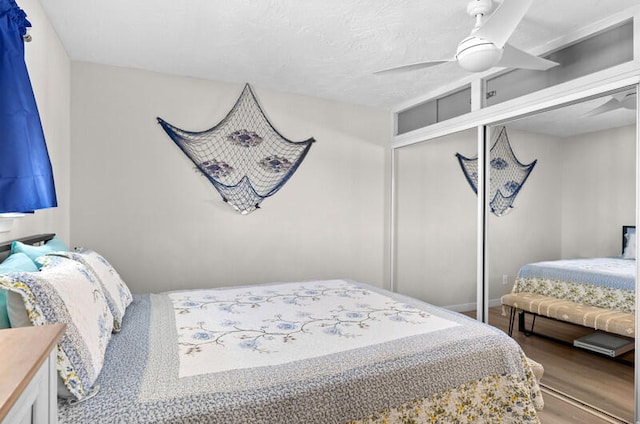 bedroom with a textured ceiling, a closet, hardwood / wood-style flooring, and ceiling fan