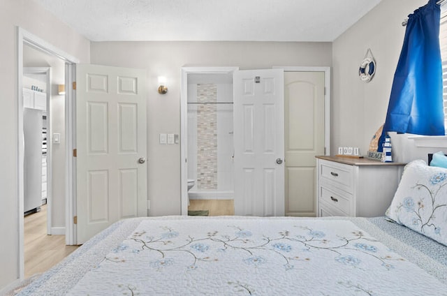 bedroom featuring light hardwood / wood-style floors and ensuite bathroom