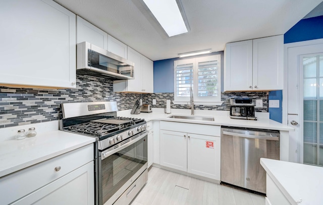 kitchen with white cabinets, plenty of natural light, sink, and appliances with stainless steel finishes