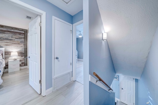 stairway with hardwood / wood-style floors and wooden walls