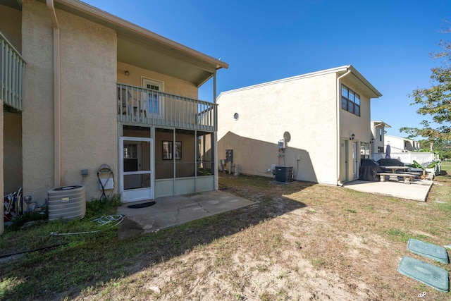 back of house with cooling unit, a balcony, and a patio