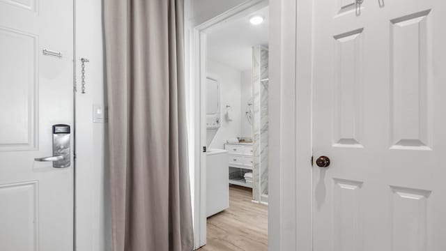 17709 Front Beach Rd Unit 2, Panama City Beach, FL 32413 - hallway with light hardwood / wood-style flooring and stacked washer / drying machine