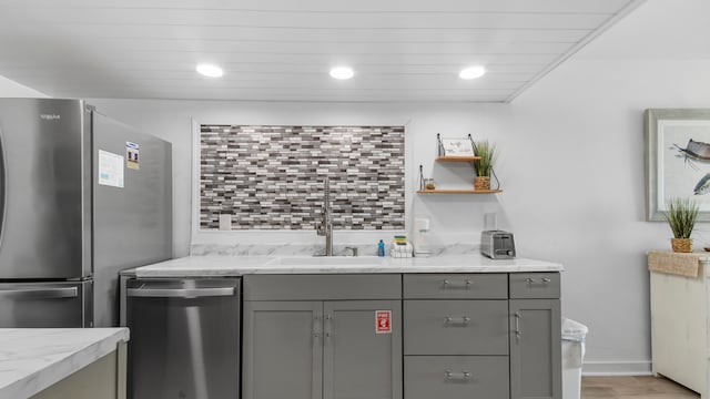 kitchen with gray cabinets, light stone countertops, sink, and appliances with stainless steel finishes