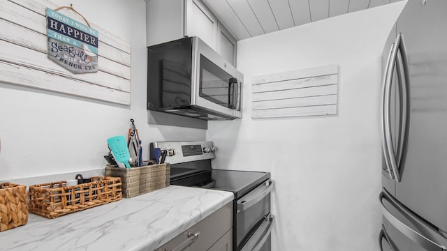 17709 Front Beach Rd Unit 2, Panama City Beach, FL 32413 - kitchen with gray cabinets, light stone countertops, and stainless steel appliances