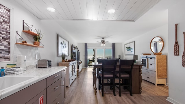 17709 Front Beach Rd Unit 2, Panama City Beach, FL 32413 - kitchen with dark brown cabinetry, ceiling fan, wooden ceiling, light hardwood / wood-style flooring, and a breakfast bar