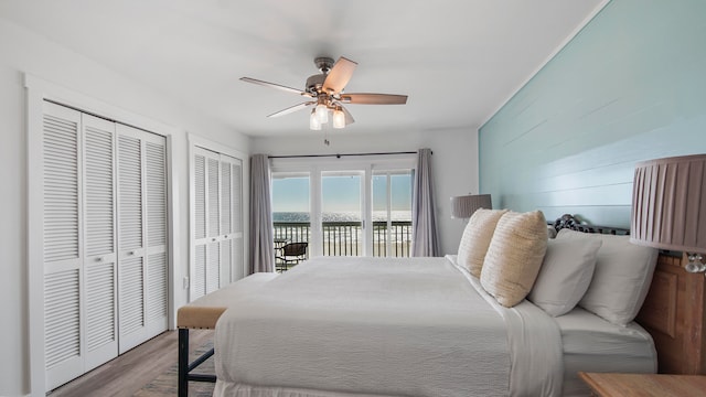 17709 Front Beach Rd Unit 2, Panama City Beach, FL 32413 - bedroom with two closets, a water view, ceiling fan, access to exterior, and wood-type flooring