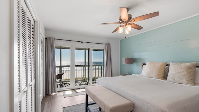17709 Front Beach Rd Unit 2, Panama City Beach, FL 32413 - bedroom featuring access to outside, ceiling fan, wood-type flooring, a water view, and wood walls