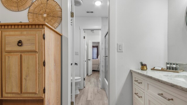 17709 Front Beach Rd Unit 2, Panama City Beach, FL 32413 - bathroom with vanity, hardwood / wood-style flooring, toilet, and walk in shower