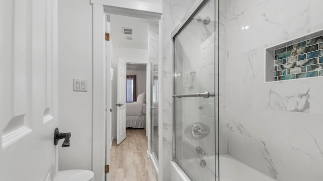 17709 Front Beach Rd Unit 2, Panama City Beach, FL 32413 - bathroom with hardwood / wood-style flooring, toilet, and enclosed tub / shower combo