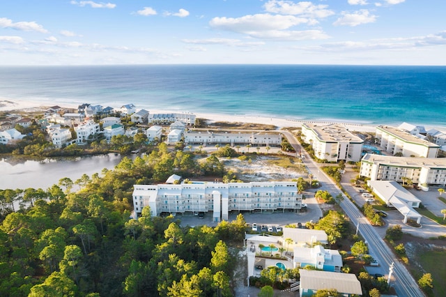 birds eye view of property with a water view and a beach view