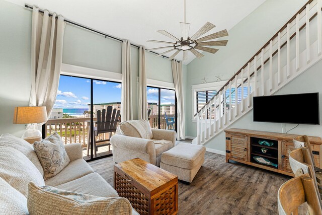 living room featuring ceiling fan, dark wood-type flooring, and a high ceiling