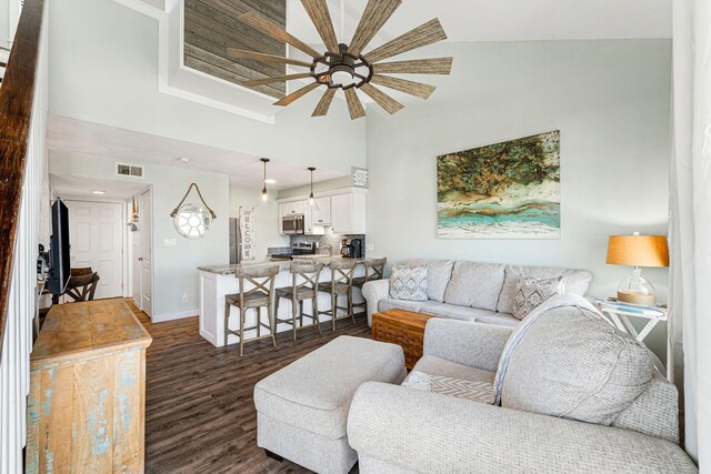 living room featuring high vaulted ceiling, ceiling fan, and dark wood-type flooring