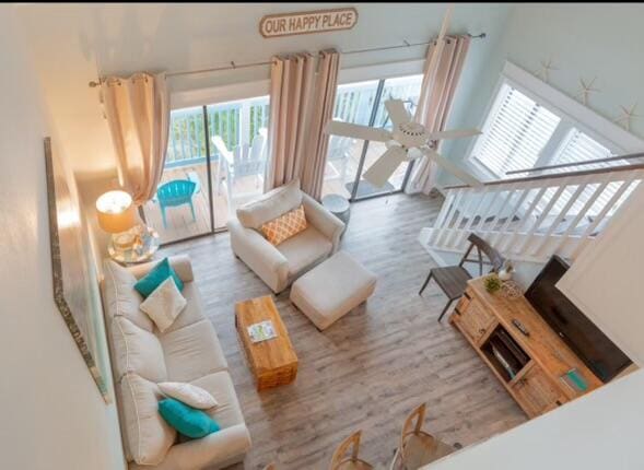 living room with light hardwood / wood-style floors, plenty of natural light, and ceiling fan