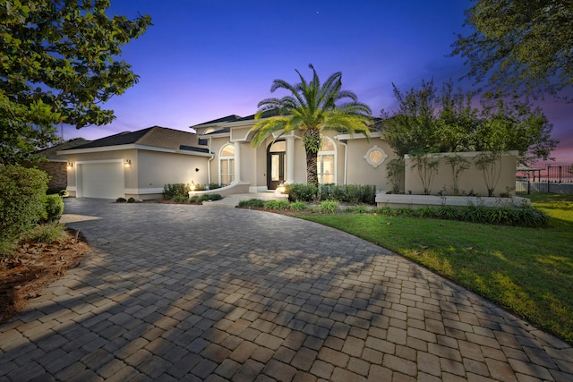 view of front of property with a garage and a lawn