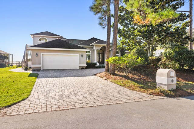 view of front of property featuring a front lawn and a garage