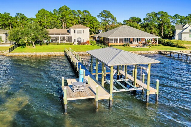 view of dock with a water view and a yard