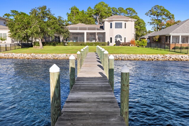 view of dock featuring a lawn and a water view