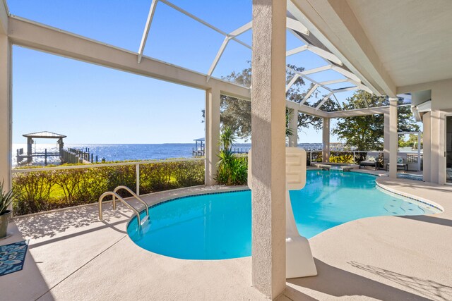 view of pool featuring a patio, a water view, and a lanai