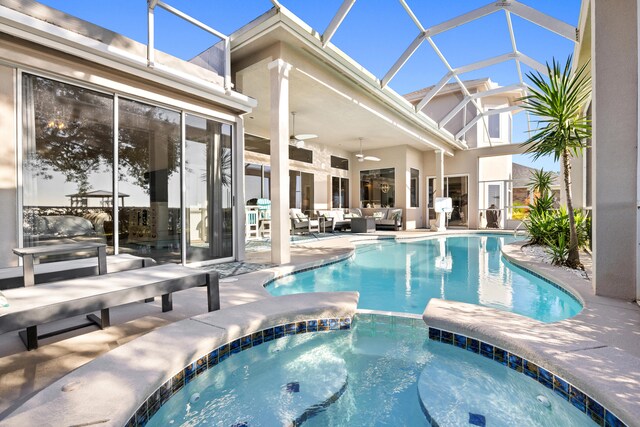 view of swimming pool with an in ground hot tub, a lanai, an outdoor living space, ceiling fan, and a patio area