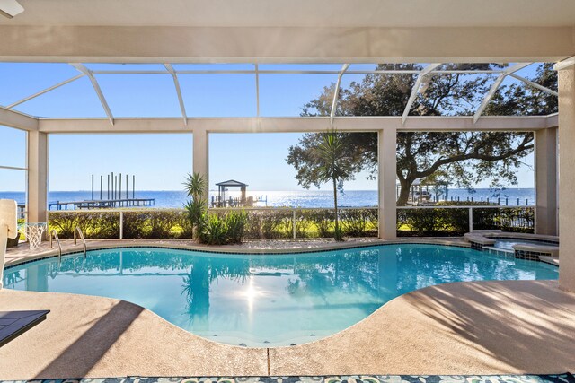 view of swimming pool featuring a lanai, a patio area, and a water view